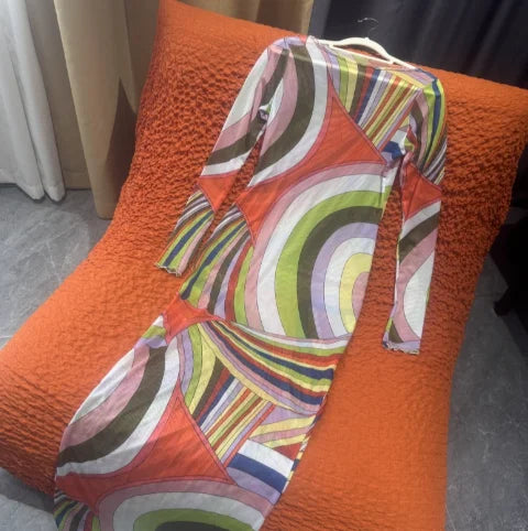 Colorful patterned garment draped over an orange textured surface