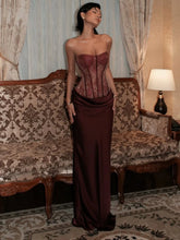 Burgundy sequin strapless corset maxi dress on a model