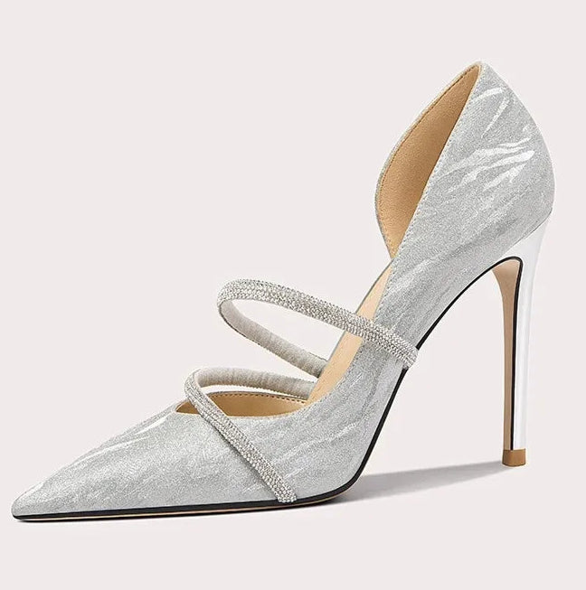 Silver high-heeled shoe with a strap on a light gray background
