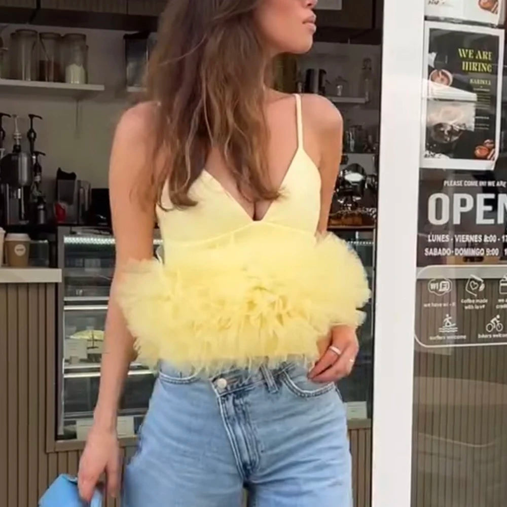 Woman wearing a yellow fluffy top and blue jeans in a cafe setting