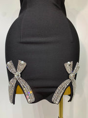 Black high-heeled shoes with decorative bows on a mannequin.