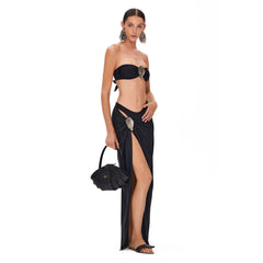 Model wearing a beige halter neck plunge swimsuit and high-slit wrap skirt
