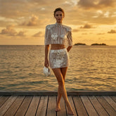 Mock neck cap sleeve crop top and mini skirt set on a wooden pier.