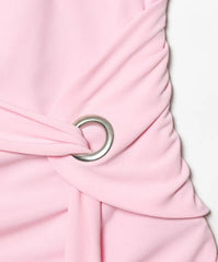 Close-up of a pink dress with a silver buckle on a light pink background