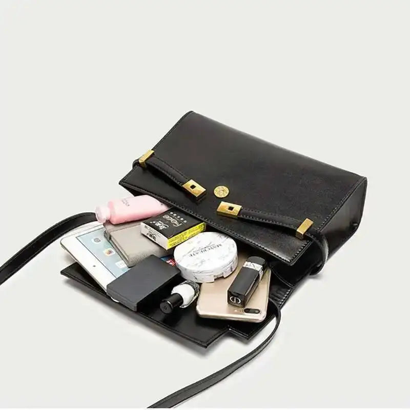 Open structured black leather flap bag showing contents