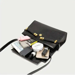 Open structured black leather flap bag showing contents