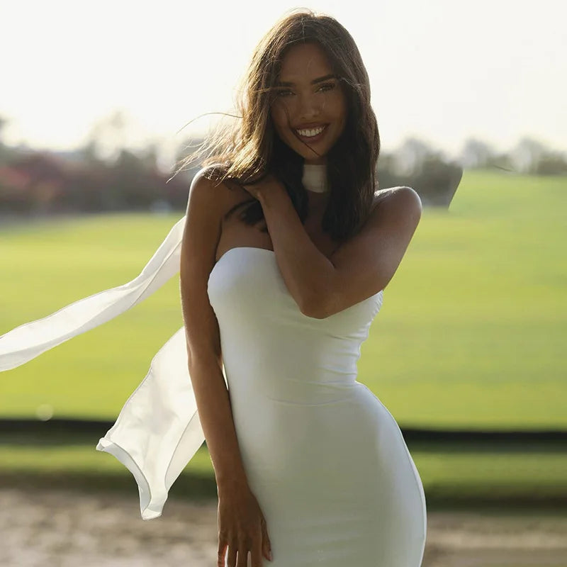 Woman in a white dress standing outdoors with a blurred background
