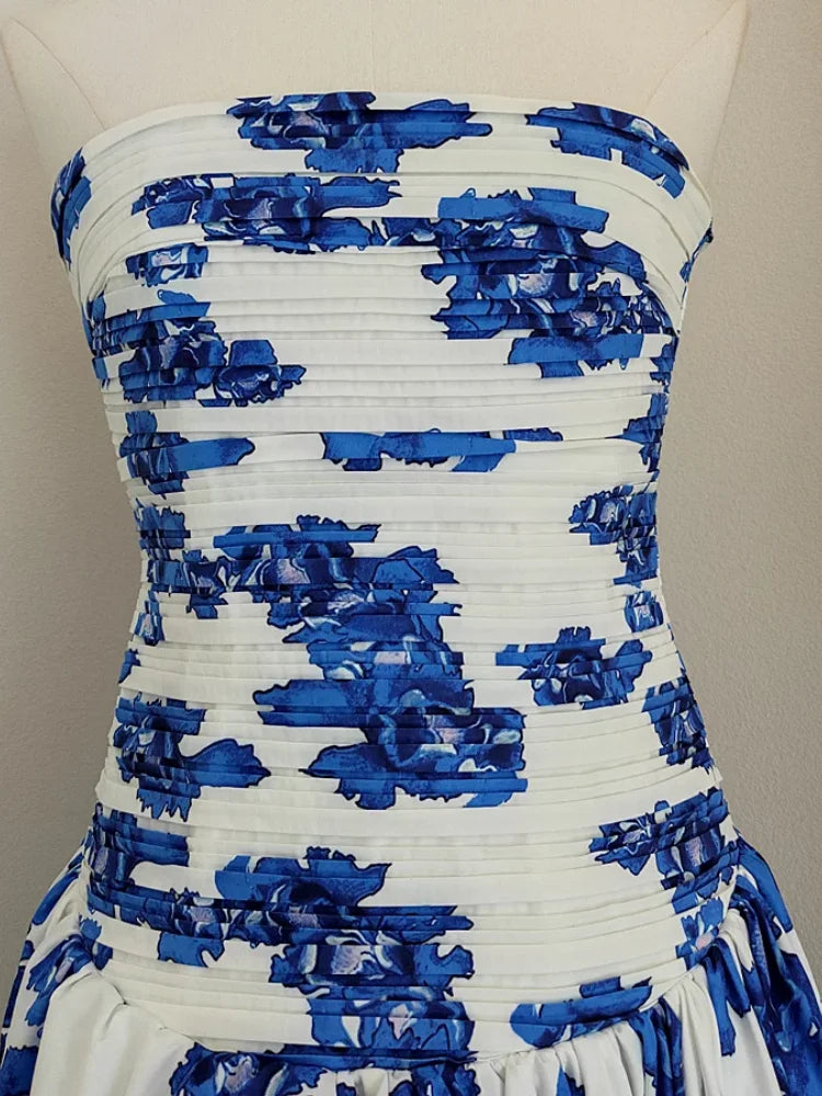 White strapless dress with blue floral patterns on a mannequin against a neutral background