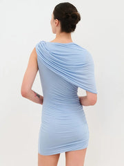Woman wearing a light blue one-shoulder dress against a plain background
