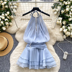 Light blue dress on a hanger with floral decorations and a hat in the background