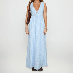 Woman wearing a blue checkered dress on a plain background