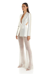 Woman wearing a white blazer and sheer pants