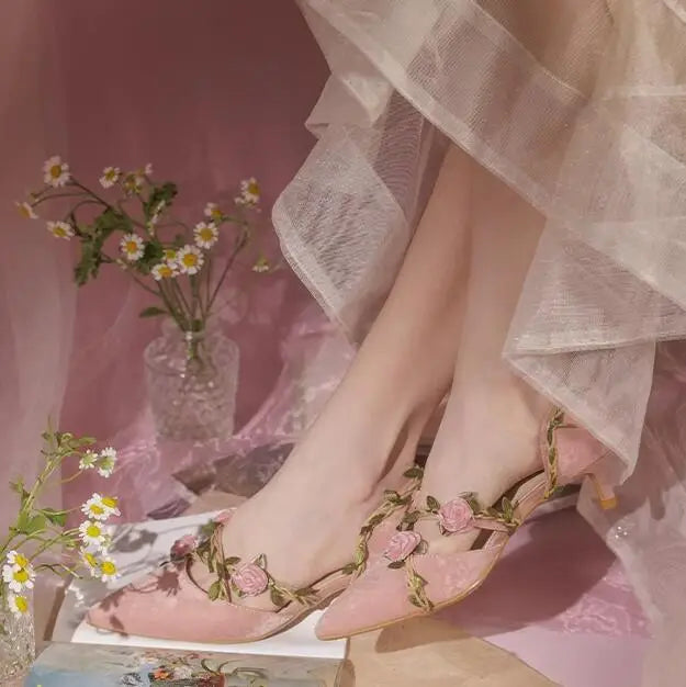 Pair of pink floral vine kitten heels on a book