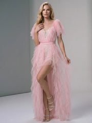 Blonde model posing in pink formal gown with high slit