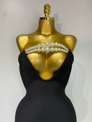 Black strapless dress with pearl embellishments on a gold mannequin against a white background