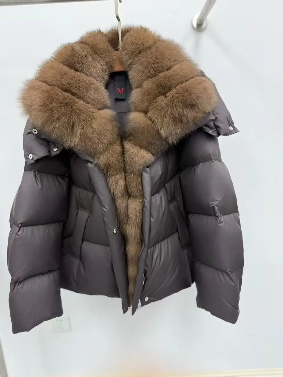 Gray puffer jacket with brown fur hood on a white background