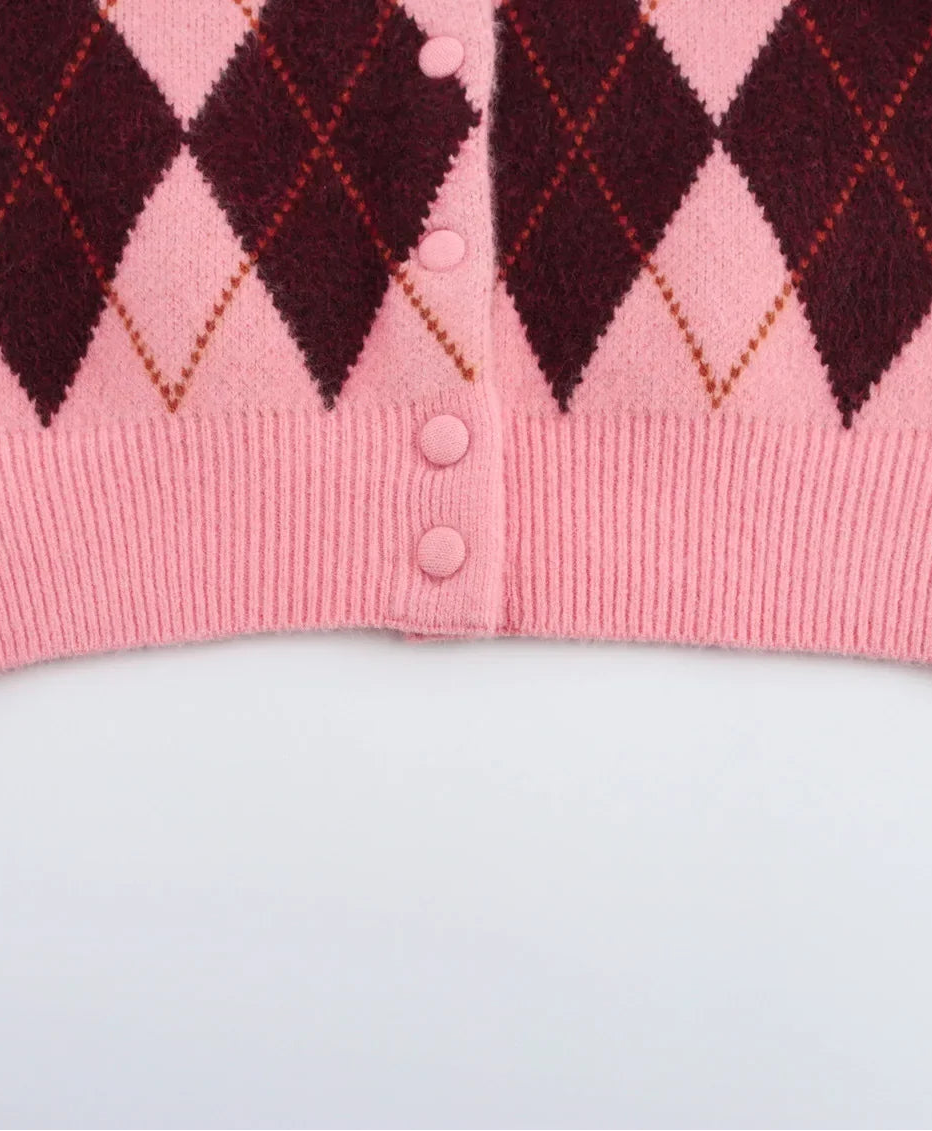 Pink sweater with argyle pattern on a white background