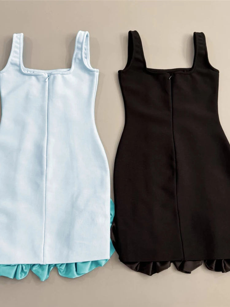 Light blue and black sleeveless dresses with ruffled hem on a beige background