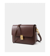 Brown leather handbag with a gold clasp on a light gray background