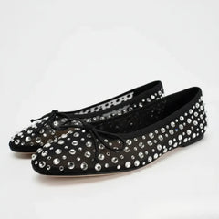 Pair of black mesh ballet flats adorned with sparkling crystals.