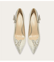 Pair of silver high-heeled shoes with butterfly embellishments on a light background