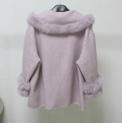 Pink coat with fur trim on a hanger against a white background