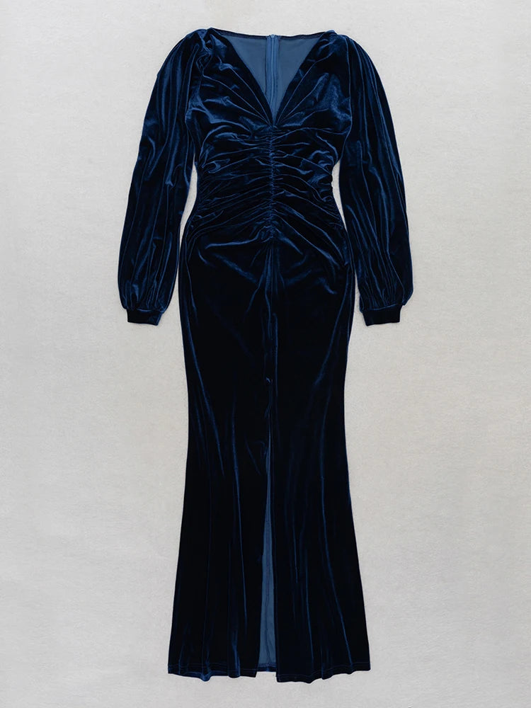 Navy velvet dress with long sleeves on a light gray background