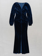 Navy velvet dress with long sleeves on a light gray background