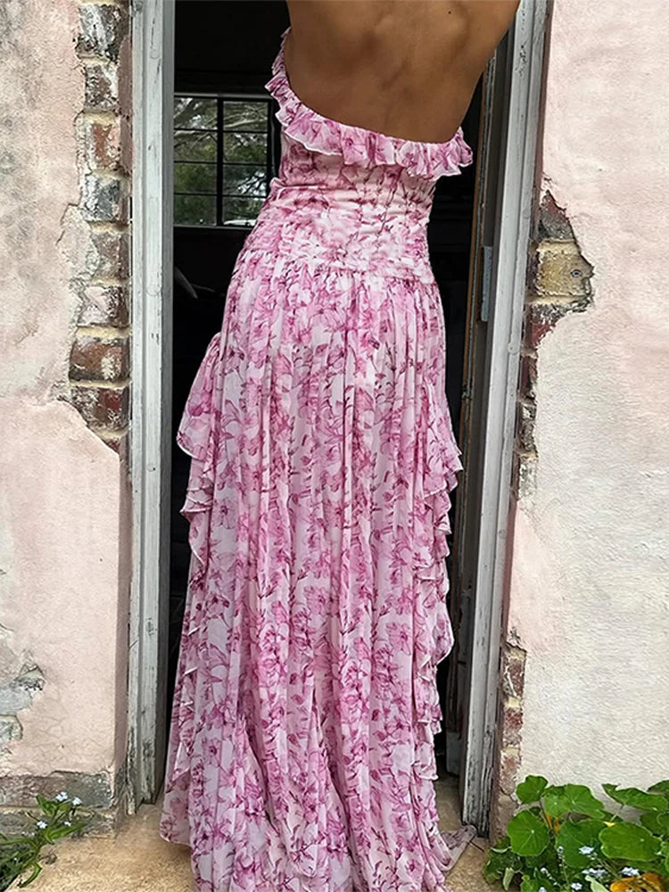 Person wearing a pink floral dress standing in a doorway.