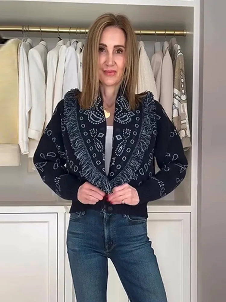 Woman wearing a dark blue patterned jacket in front of a wardrobe with white clothes.