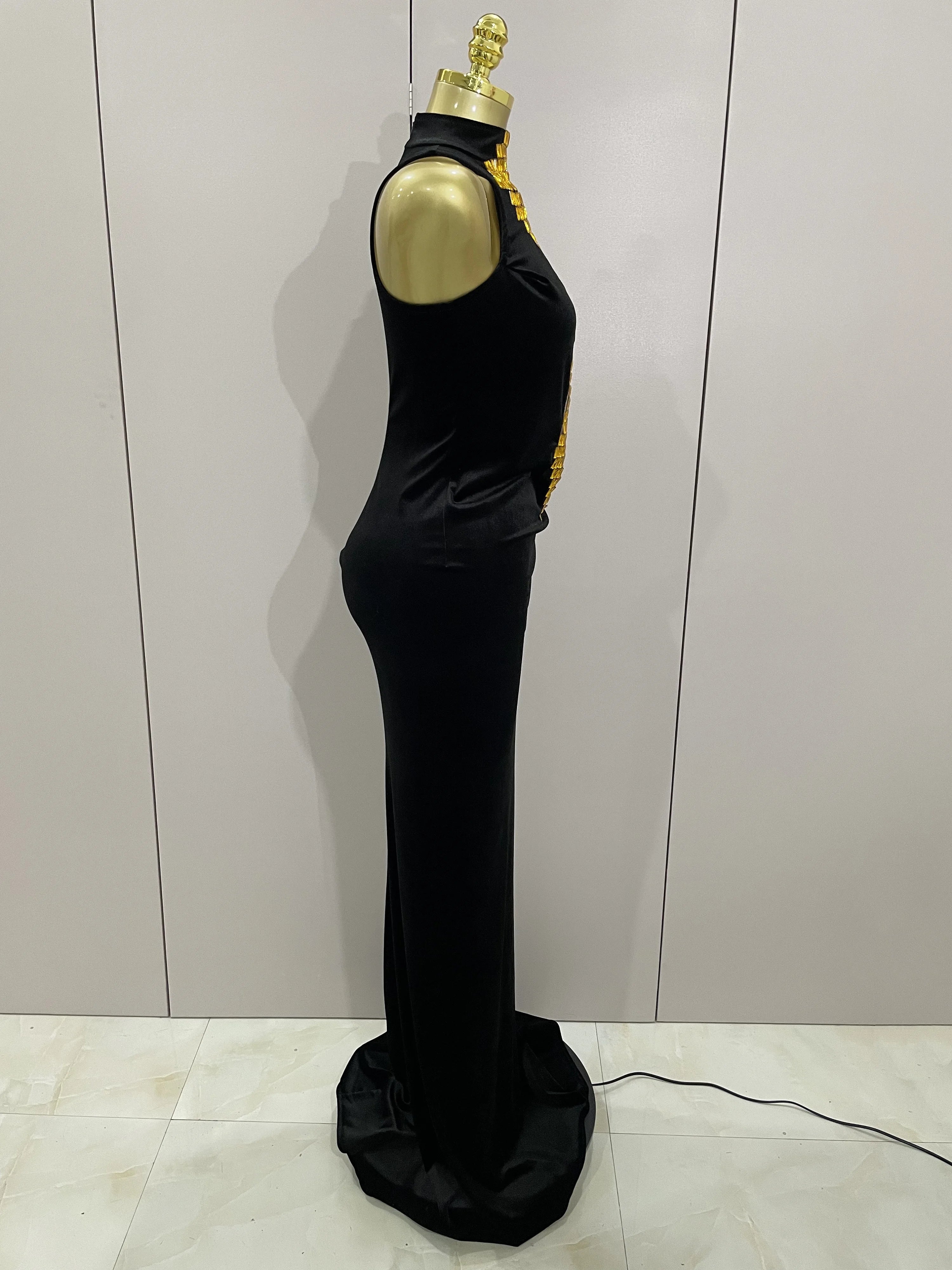Black evening gown on a mannequin against a light gray wall.