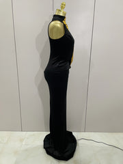 Black evening gown on a mannequin against a light gray wall.