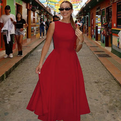 Woman in a red dress standing on a street with colorful buildings in the background