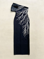 Black evening gown with silver bead detailing on a beige background