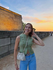 Woman smiling in a knit military vest at sunset