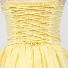 Yellow dress with criss-cross straps on a white background