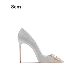 Silver high-heeled shoe with decorative elements on a white background