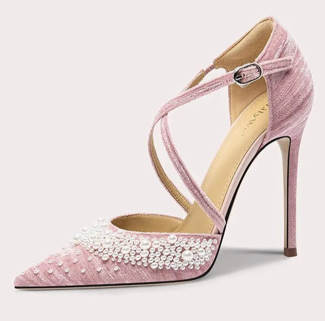Pink high-heeled shoe with pearl details on a white background