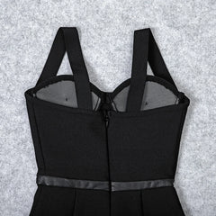Black dress with thin straps on a textured gray background