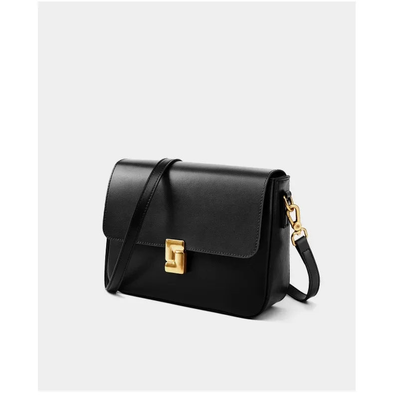 Black handbag with a gold clasp on a white background