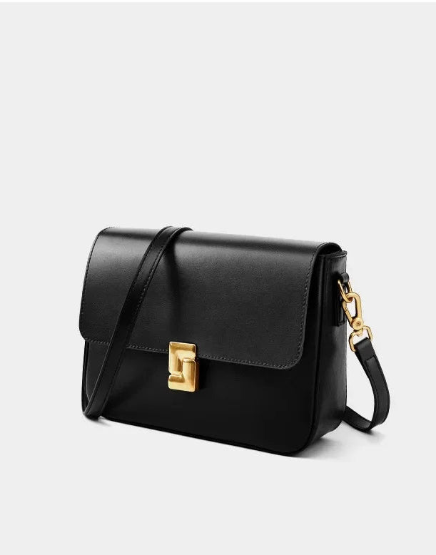 Black handbag with a gold clasp on a white background