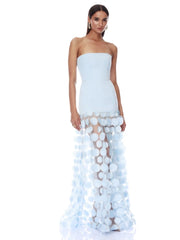 Woman wearing a strapless light blue gown with floral details on a white background