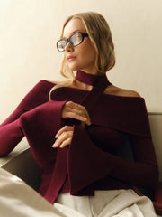 Woman wearing a burgundy sweater with a neutral background