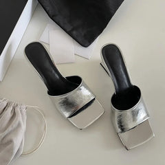 Two metallic shoe polish cups with black handles on a light surface.