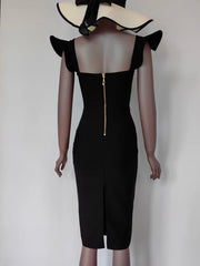 Black dress with ruffled shoulders on a mannequin against a plain background