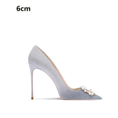 High-heeled shoe with pearl embellishments on a white background
