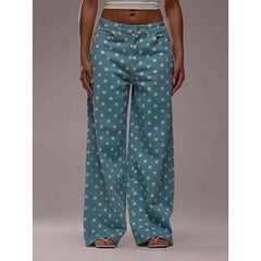 Teal pants with white polka dots worn by a person on a gray background