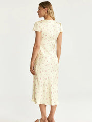 Woman wearing a cream-colored dress with a subtle pattern on a white background