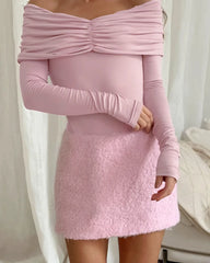 Pink long-sleeve top and skirt set against a white background