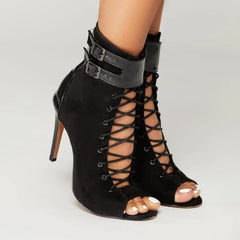 Black high-heeled lace-up sandals on a neutral background